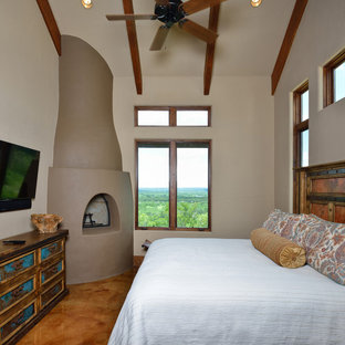 Diseño de habitación de invitados rural con suelo de cemento, chimenea de esquina y marco de chimenea de yeso
