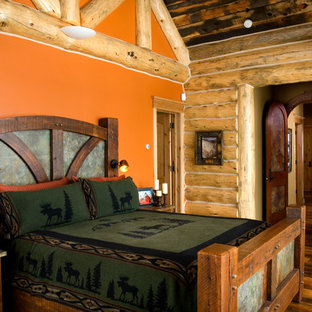 Foto de dormitorio rural con parades naranjas y suelo de madera en tonos medios