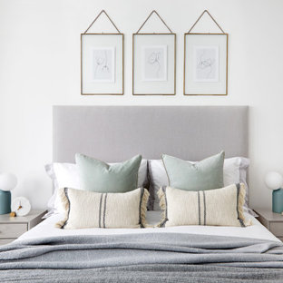 Inspiration for a scandinavian bedroom in London with white walls, medium hardwood flooring and brown floors.