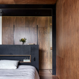 Design ideas for a mid-sized contemporary master bedroom in Melbourne with brown walls, medium hardwood floors, brown floor, timber and wood walls.