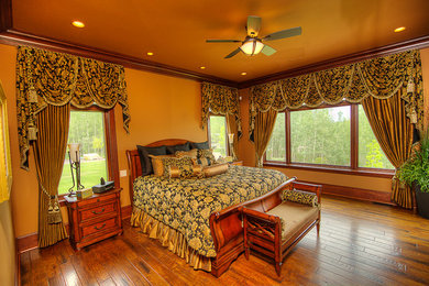 Foto de dormitorio clásico de tamaño medio con parades naranjas y suelo de madera oscura