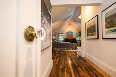 Transitional master medium tone wood floor bedroom photo in Toronto with white walls