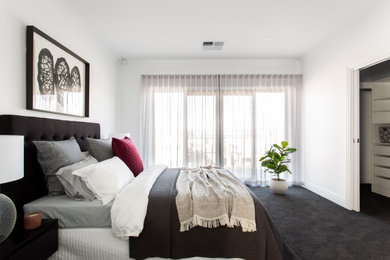 Imagen de dormitorio actual con paredes blancas, moqueta y suelo negro