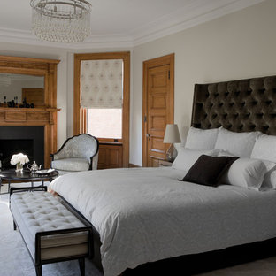 Inspiration for a timeless bedroom remodel in New York with beige walls, a standard fireplace and a wood fireplace surround