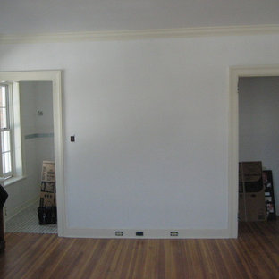 Imagen de habitación de invitados clásica, grande, con parades naranjas, suelo de madera en tonos medios, chimenea tradicional y marco de chimenea de piedra