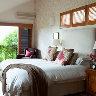This is an example of a large beach style master bedroom in Brisbane with white walls and medium hardwood floors.