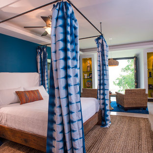 Foto de dormitorio principal, tropical, grande, con paredes azules y suelo de mármol