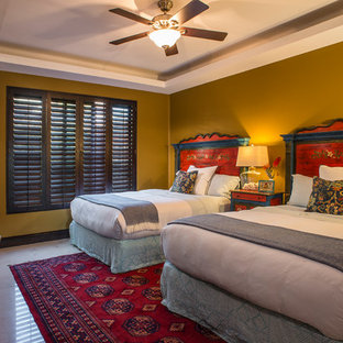 Imagen de habitación de invitados tropical, de tamaño medio, con paredes amarillas y suelo de mármol