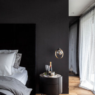 Inspiration for a contemporary bedroom in Sydney with black walls, medium hardwood floors and brown floor.