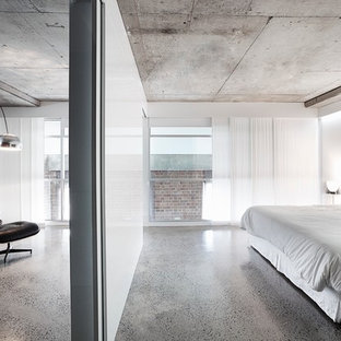 Foto de dormitorio actual con paredes blancas, suelo de cemento y suelo gris
