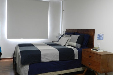 Imagen de dormitorio tipo loft pequeño sin chimenea con paredes beige y suelo de madera en tonos medios