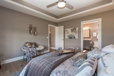 グランドラピッズにある中くらいなトラディショナルスタイルのおしゃれな主寝室 (グレーの壁、淡色無垢フローリング、暖炉なし)