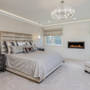 Aménagement d'une chambre méditerranéenne avec un mur beige, une cheminée ribbon et un sol beige.