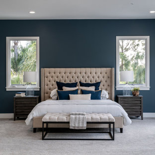 Geräumiges Mediterranes Hauptschlafzimmer mit blauer Wandfarbe, Teppichboden, Kamin, gefliester Kaminumrandung und grauem Boden in San Diego