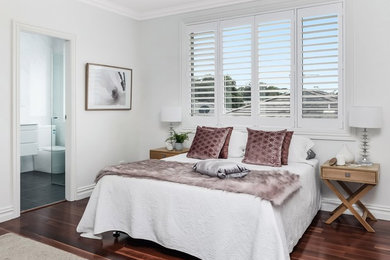 シドニーにあるトランジショナルスタイルのおしゃれな主寝室 (ベージュの壁、濃色無垢フローリング、赤い床) のインテリア