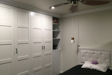 Medium sized modern bedroom in Brisbane with white walls and carpet.