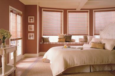 Diseño de dormitorio principal clásico de tamaño medio sin chimenea con paredes marrones, suelo de madera clara y suelo beige