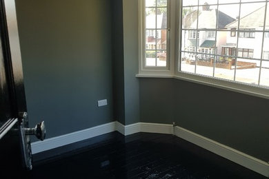 Medium sized scandi master bedroom in West Midlands with grey walls and black floors.