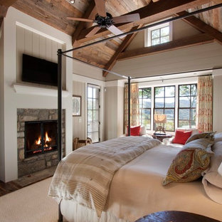 This is an example of a country bedroom in Other with a standard fireplace and a stone fireplace surround.