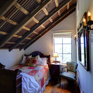 Foto de dormitorio tipo loft, rural, pequeño, con paredes beige y suelo de madera en tonos medios