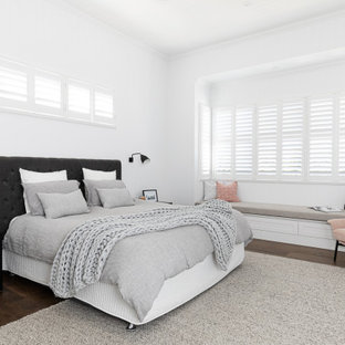 Design ideas for a transitional guest bedroom in Brisbane with white walls, medium hardwood floors, no fireplace and brown floor.