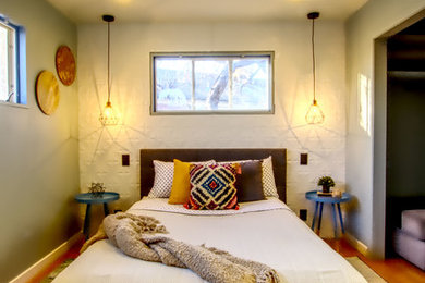 Example of a mid-sized trendy guest medium tone wood floor and brown floor bedroom design in Denver with gray walls and no fireplace