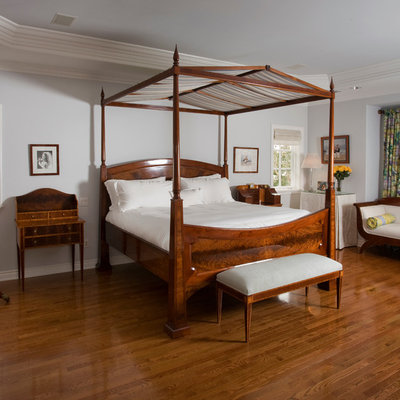 Example of a classic master medium tone wood floor bedroom design in Orange County with gray walls and no fireplace