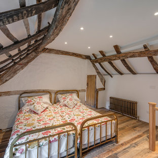 Diseño de habitación de invitados clásica, pequeña, con paredes blancas, suelo de madera en tonos medios y suelo marrón