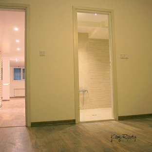 Diseño de dormitorio principal, actual, de tamaño medio, con paredes beige, suelo laminado y suelo marrón