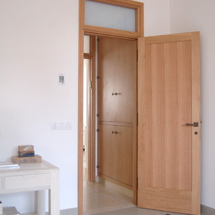 Diseño de dormitorio principal, actual, grande, con paredes blancas, suelo de piedra caliza y suelo beige