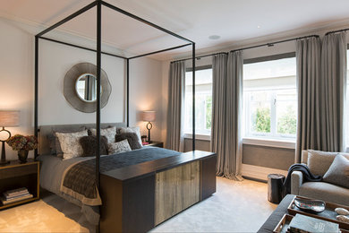 Contemporary master bedroom in London with beige walls, carpet and beige floors.