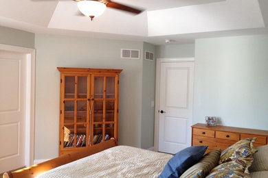 他の地域にある中くらいなトラディショナルスタイルのおしゃれな客用寝室 (青い壁、カーペット敷き) のインテリア