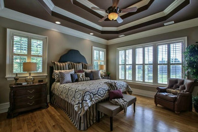 Mid-sized transitional master medium tone wood floor and brown floor bedroom photo in Miami with gray walls and no fireplace