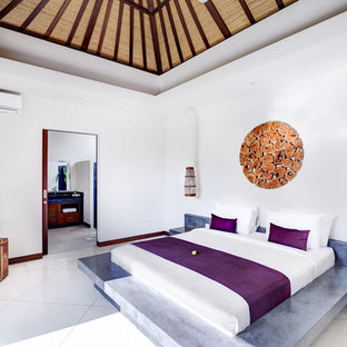 Imagen de dormitorio principal, tropical, con paredes blancas