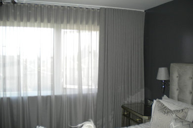 Imagen de dormitorio principal moderno grande con paredes grises