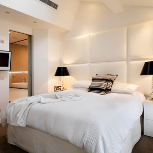 Photo of a contemporary bedroom in London with white walls and carpet.
