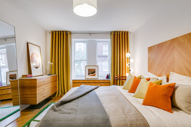 Diseño de dormitorio principal actual de tamaño medio con paredes blancas y suelo marrón