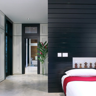 Example of a mid-sized trendy master concrete floor and gray floor bedroom design in Miami with white walls and no fireplace