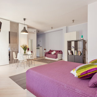 Diseño de dormitorio tipo loft, actual, de tamaño medio, con paredes púrpuras, suelo de madera clara y suelo beige