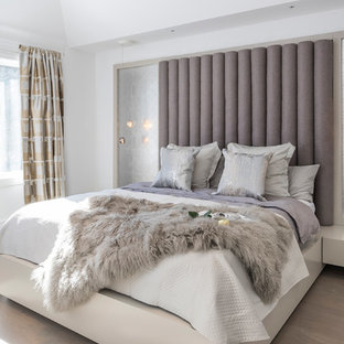 Großes Modernes Hauptschlafzimmer mit weißer Wandfarbe, hellem Holzboden, Kamin, Kaminumrandung aus Beton und grauem Boden in Toronto