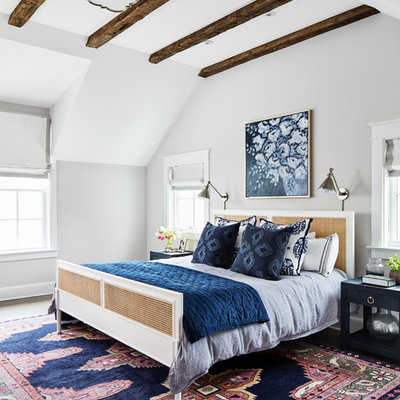 Example of a beach style medium tone wood floor and brown floor bedroom design in DC Metro with white walls