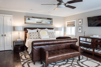 Large traditional master bedroom in New York with grey walls, dark hardwood flooring and no fireplace.