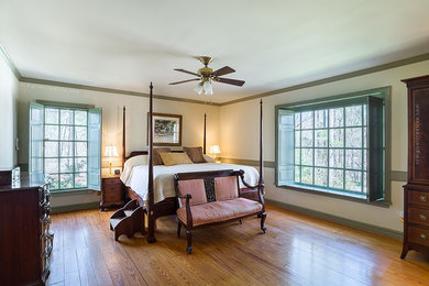 Ejemplo de dormitorio principal clásico grande sin chimenea con paredes blancas y suelo de madera en tonos medios
