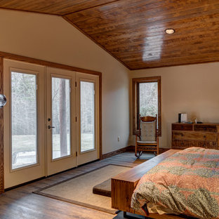 Ispirazione per una grande camera matrimoniale stile rurale con pareti beige, parquet chiaro e camino sospeso