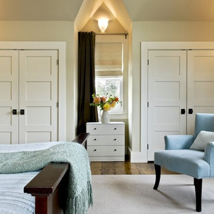 Immagine di una camera da letto stile rurale con pareti beige e pavimento in legno massello medio