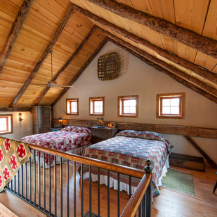Ejemplo de dormitorio tipo loft, rural, con paredes blancas y suelo de madera en tonos medios