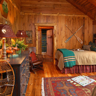 Diseño de habitación de invitados rural, grande, sin chimenea, con paredes beige y suelo de madera en tonos medios