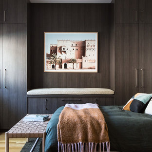 Design ideas for a beach style bedroom in Melbourne with brown walls, light hardwood floors and beige floor.