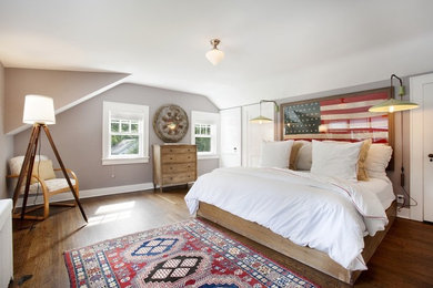 Diseño de habitación de invitados campestre grande sin chimenea con paredes beige y suelo de madera en tonos medios