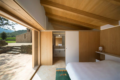 Modelo de dormitorio principal minimalista de tamaño medio sin chimenea con paredes blancas y suelo de piedra caliza